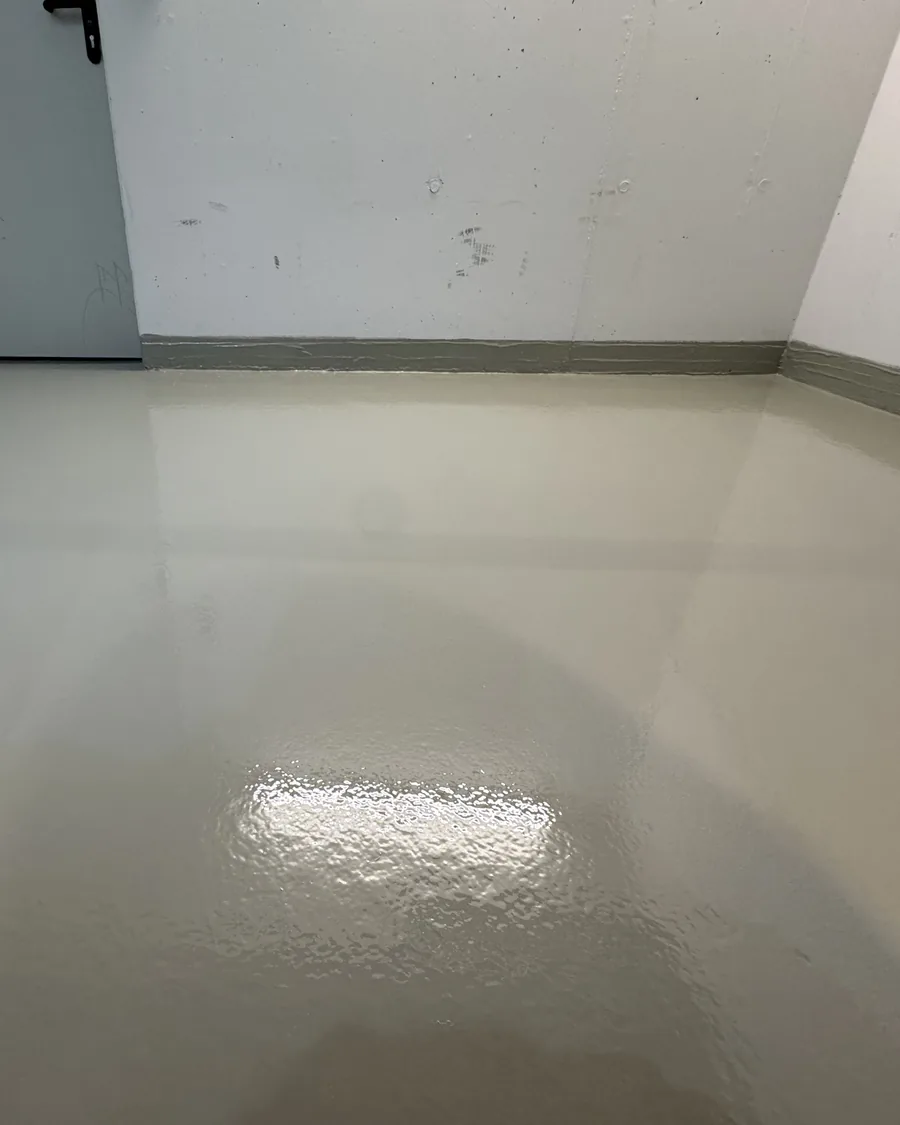 Frisch beschichteter Boden mit geschlossener, glänzender Oberfläche und hochgezogener Hohlkehle am Wandanschluss