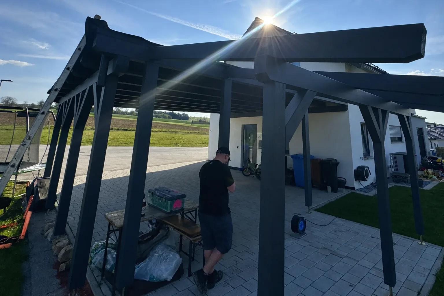 Individuell geplanter Carport mit auskragenden Balken und Schrägstreben, an den Bestand angepasst