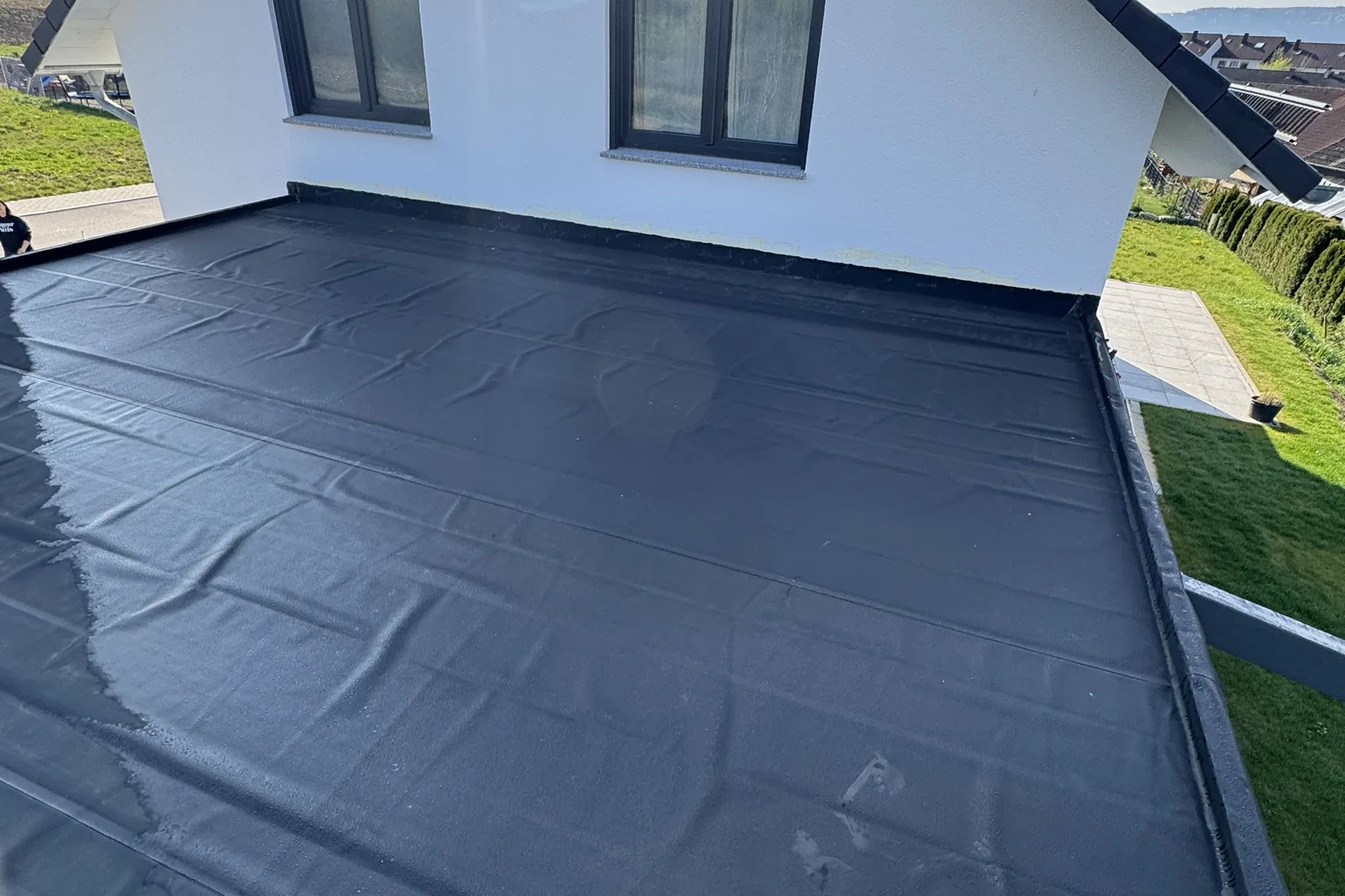 Frisch verlegte Flachdachabdichtung auf einem Wohnhaus.