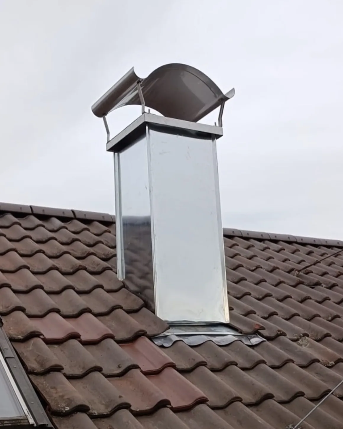 Schornsteinkopf mit neuer Edelstahlverkleidung und Regenhaube, ausgeführt von Der Abdichter